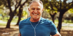 Older male with blue t-shirt listening to headphones